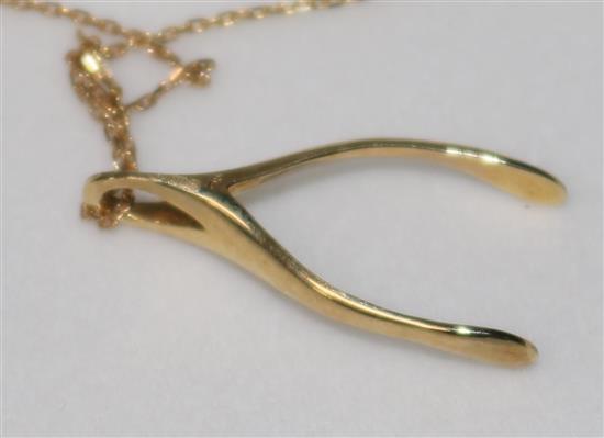 A 9ct gold wishbone pendant, on fine gold chain.